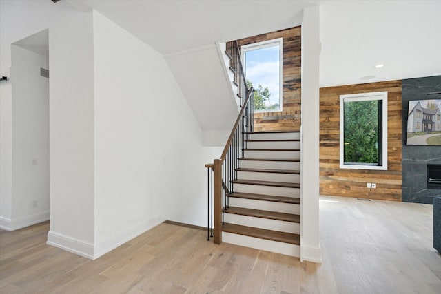 stairway featuring wood walls and hardwood / wood-style flooring