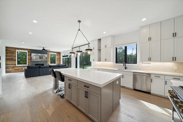 kitchen with appliances with stainless steel finishes, ceiling fan, decorative light fixtures, a center island, and white cabinetry