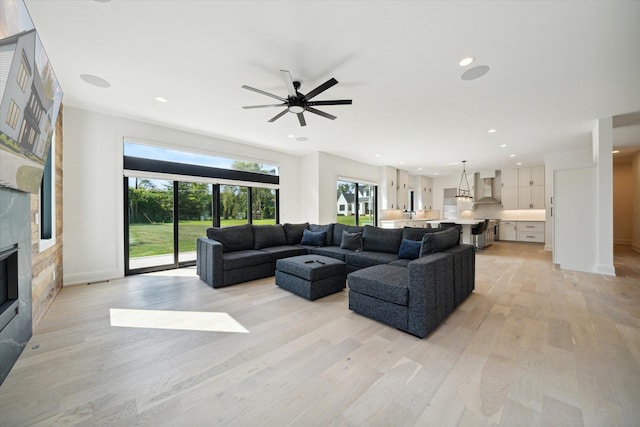 living room with light hardwood / wood-style flooring and ceiling fan