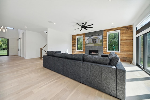 living room with a fireplace, a wealth of natural light, and light hardwood / wood-style flooring