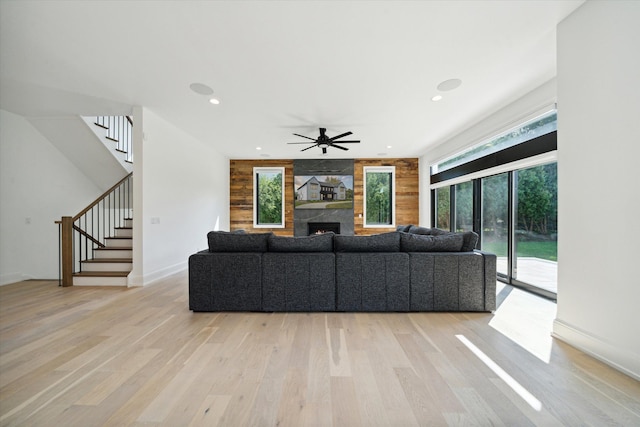 living room with a fireplace, light hardwood / wood-style flooring, and ceiling fan