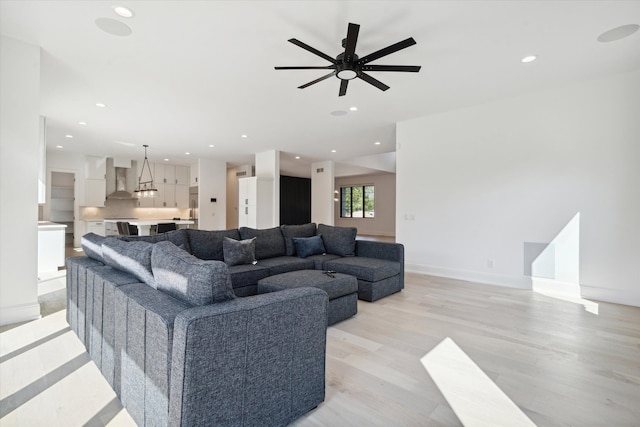 living room featuring ceiling fan and light wood-type flooring