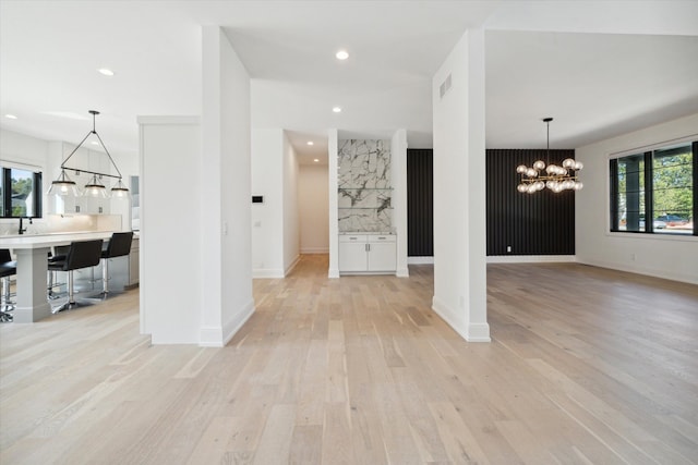 unfurnished living room featuring light hardwood / wood-style flooring and an inviting chandelier