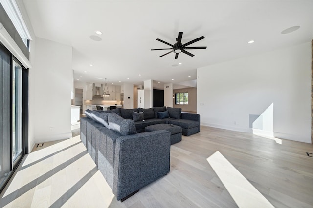 living room with ceiling fan and light hardwood / wood-style flooring