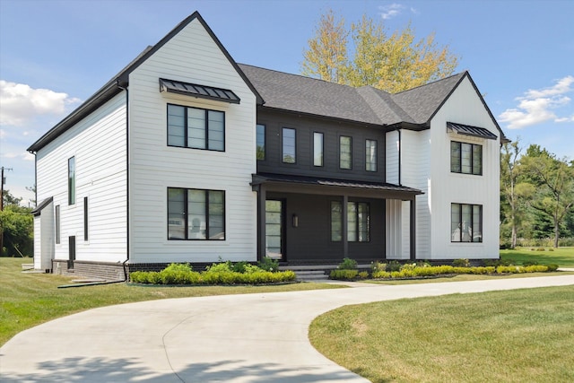 modern inspired farmhouse with a front yard and a porch