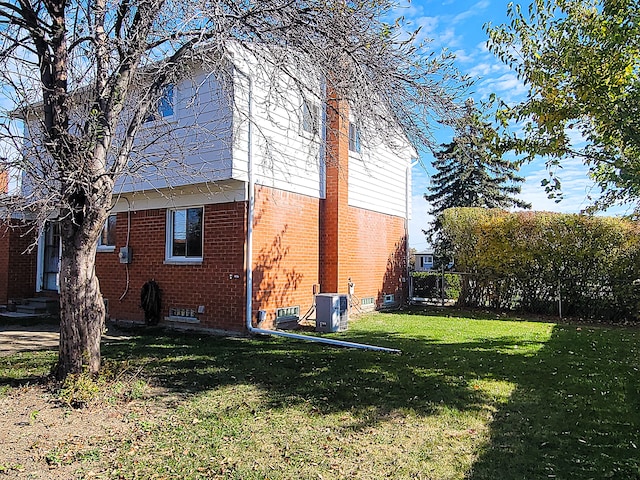 view of property exterior featuring a lawn and central air condition unit