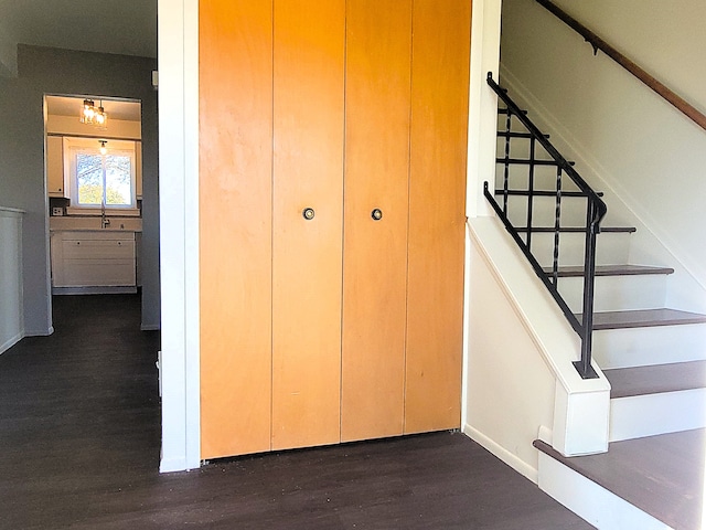 stairs featuring hardwood / wood-style flooring and sink