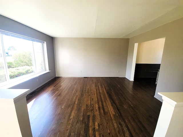 unfurnished living room featuring dark wood-type flooring