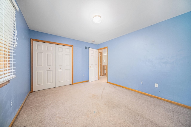 unfurnished bedroom with carpet flooring and a closet