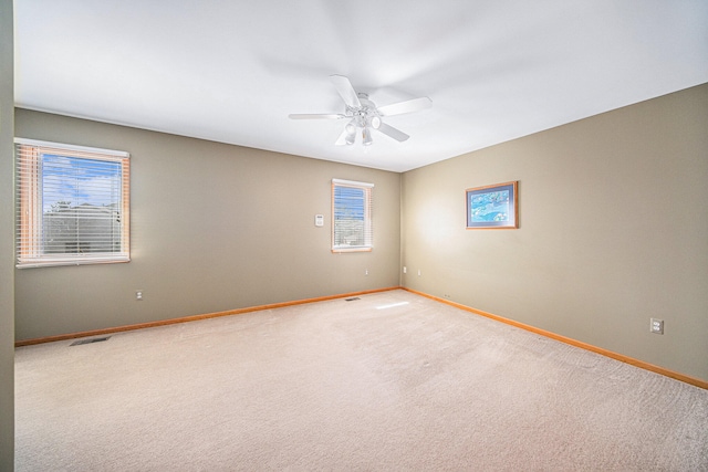 unfurnished room with ceiling fan and carpet