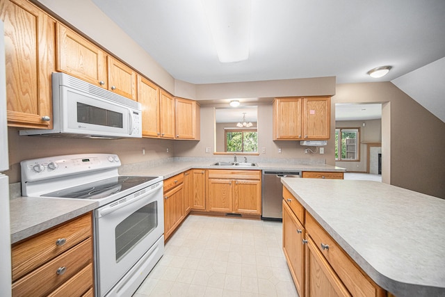 kitchen with sink, a chandelier, and white appliances