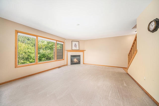 unfurnished living room featuring light carpet and a fireplace