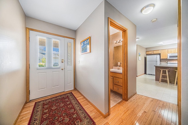 doorway featuring light wood-type flooring and sink