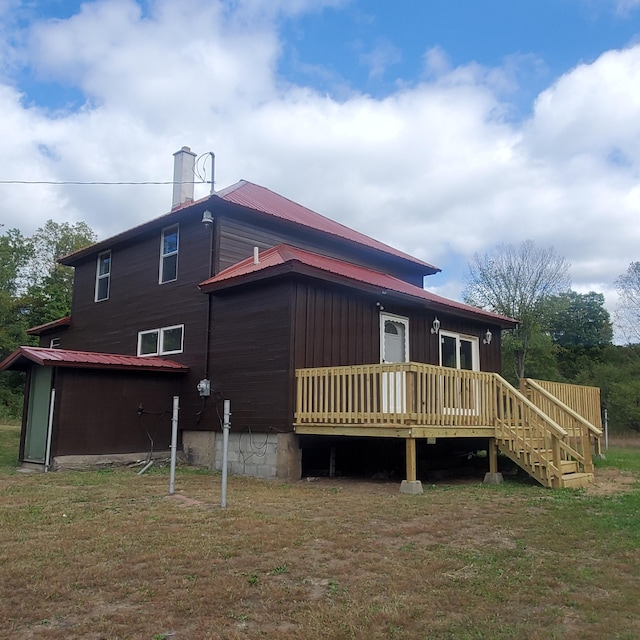 rear view of house with a yard and a wooden deck