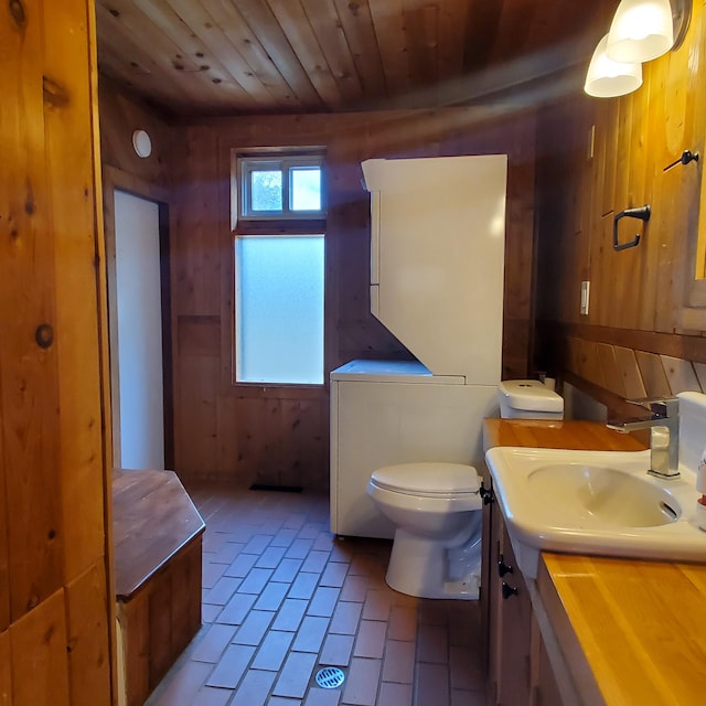 bathroom featuring vanity, wooden ceiling, wooden walls, tile patterned flooring, and toilet