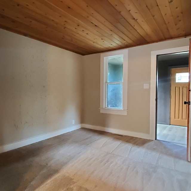 empty room featuring light colored carpet and wood ceiling