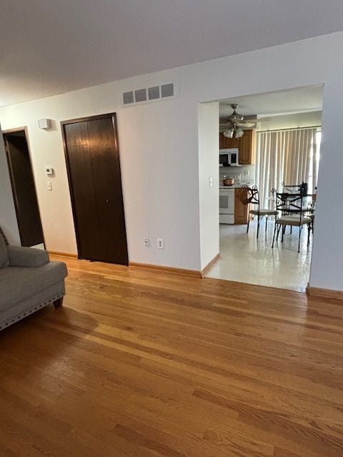 living room featuring ceiling fan and light hardwood / wood-style flooring