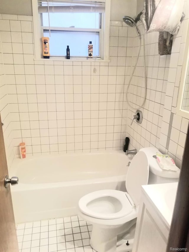 full bathroom featuring tile patterned flooring, tiled shower / bath combo, toilet, and vanity