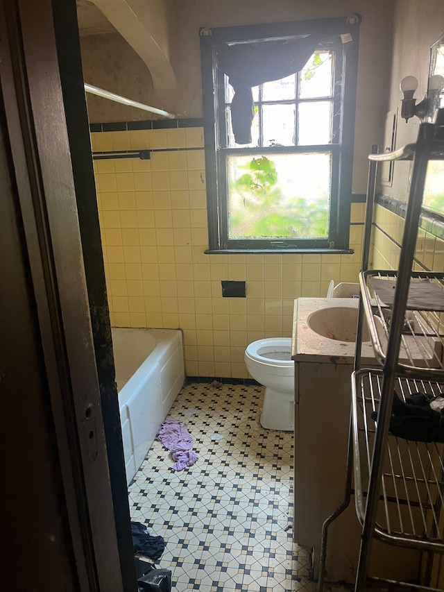 bathroom with vanity, toilet, and tile walls