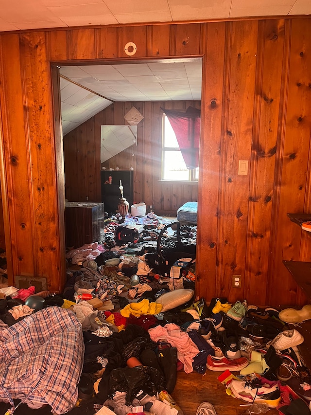 miscellaneous room featuring lofted ceiling and wooden walls