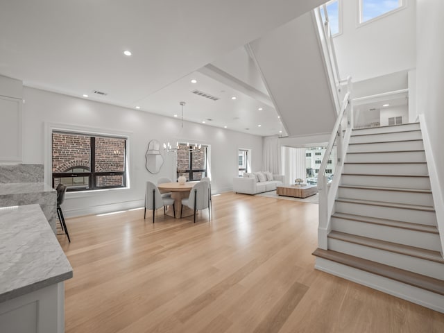 living room featuring light hardwood / wood-style floors, a wealth of natural light, and a notable chandelier