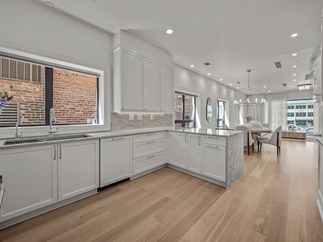 kitchen featuring light hardwood / wood-style floors, white cabinetry, a wealth of natural light, and sink