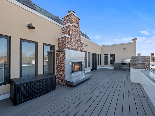 wooden terrace featuring exterior fireplace