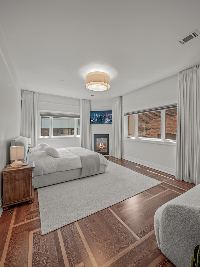 bedroom featuring multiple windows and dark wood-type flooring