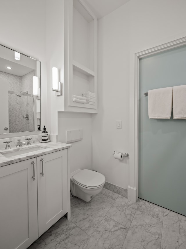 bathroom featuring vanity, an enclosed shower, and toilet