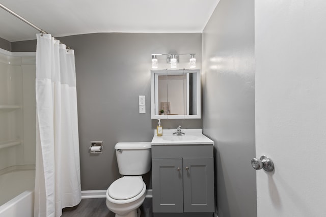 full bathroom featuring hardwood / wood-style floors, vanity, shower / tub combo, and toilet