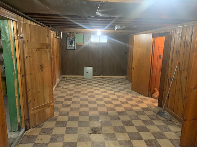 basement with electric panel and wooden walls