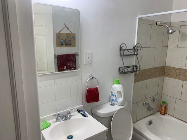 full bathroom with backsplash, vanity, tiled shower / bath combo, and toilet