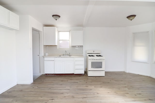 kitchen with tasteful backsplash, sink, light hardwood / wood-style floors, and white gas range oven