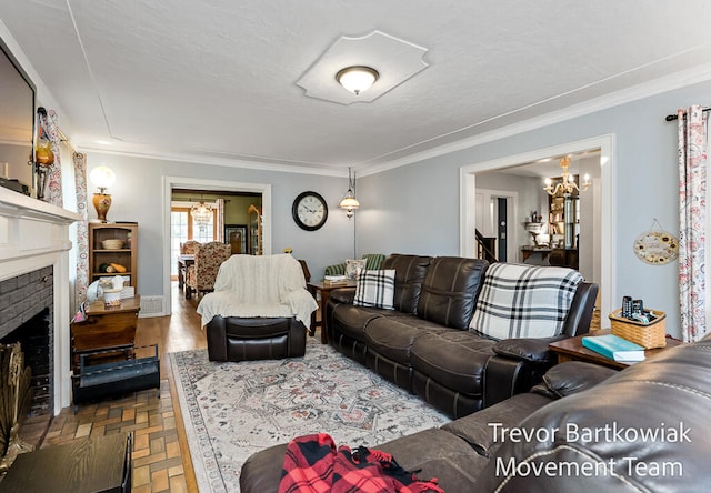 living room with a fireplace, ornamental molding, and a notable chandelier