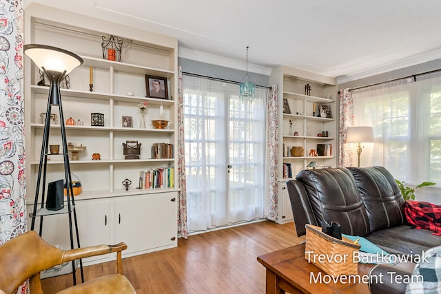 living area with crown molding and light hardwood / wood-style floors