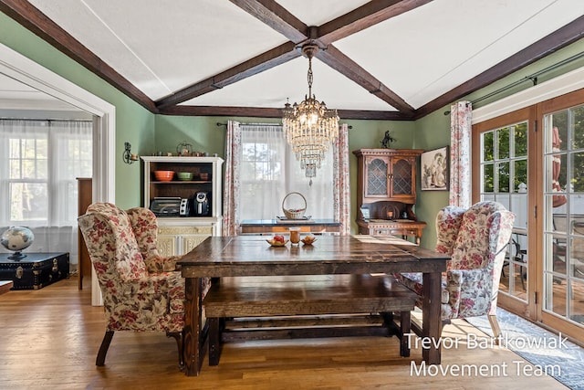 dining space featuring a chandelier, hardwood / wood-style flooring, and beamed ceiling