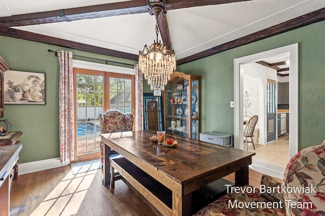 dining area featuring vaulted ceiling with beams, dark hardwood / wood-style flooring, and a chandelier