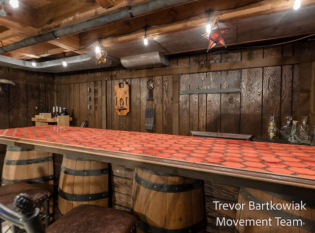 bar with dark brown cabinetry and wooden walls