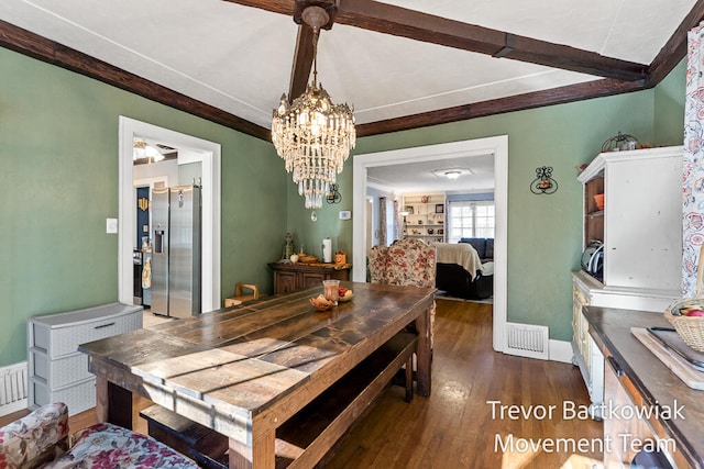 dining space with dark wood-type flooring and an inviting chandelier