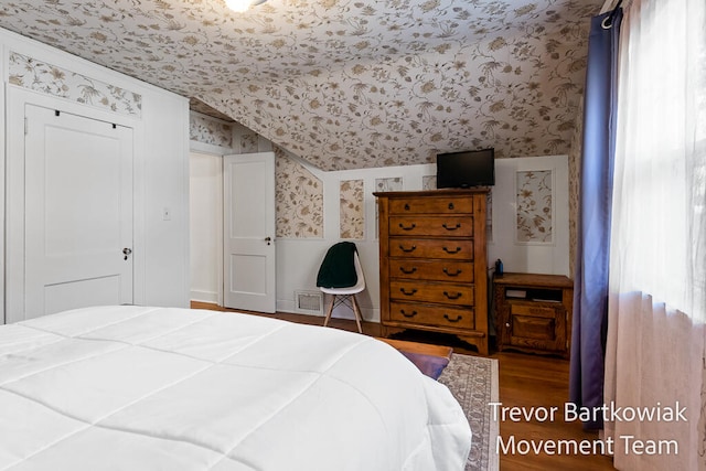 bedroom with wood-type flooring and lofted ceiling