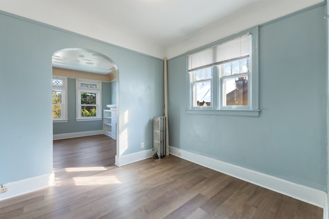 empty room featuring radiator heating unit and wood-type flooring