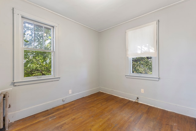 spare room featuring radiator and hardwood / wood-style flooring