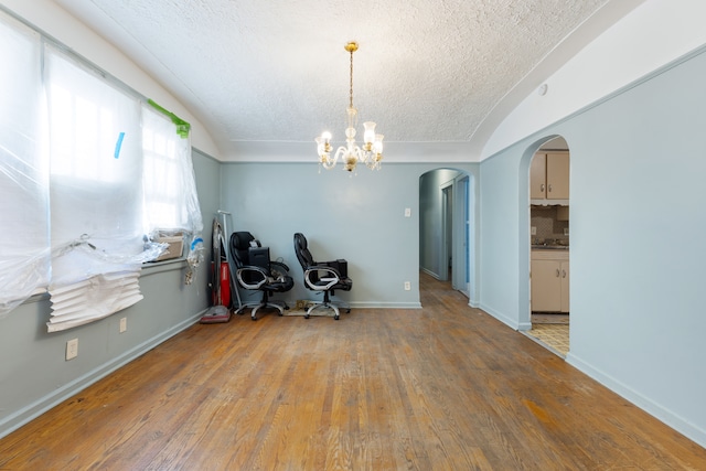 interior space featuring a textured ceiling, a notable chandelier, and hardwood / wood-style flooring