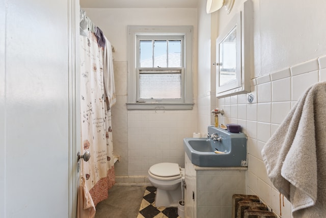 bathroom with vanity, toilet, walk in shower, and tile walls