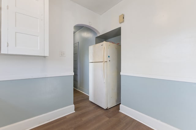 kitchen with white cabinets, white fridge, and wood-type flooring