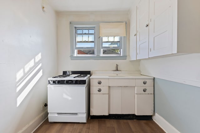 kitchen with gas range gas stove, sink, white cabinets, and dark hardwood / wood-style floors