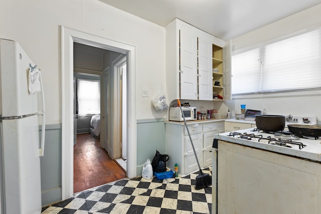 kitchen featuring white cabinetry, dark wood-type flooring, and white appliances