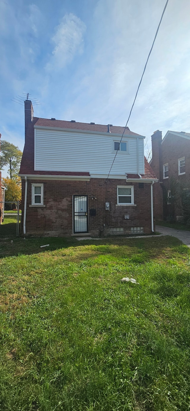 rear view of property with a lawn