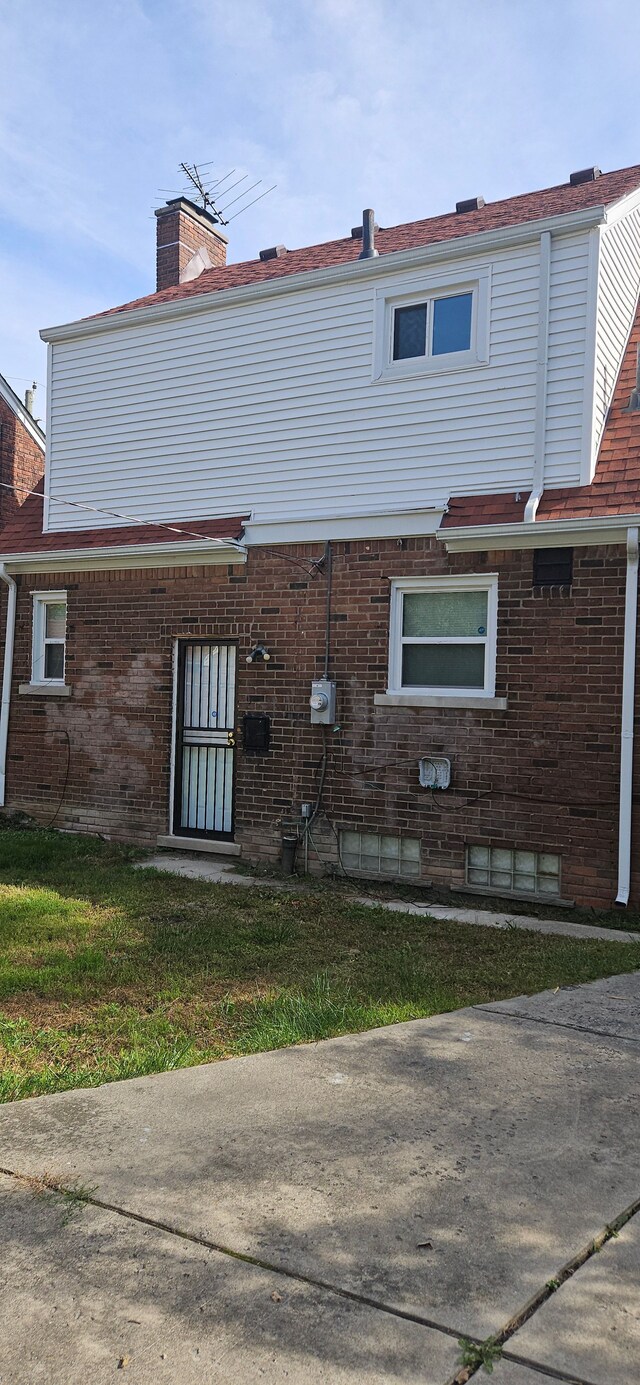 back of house featuring a lawn