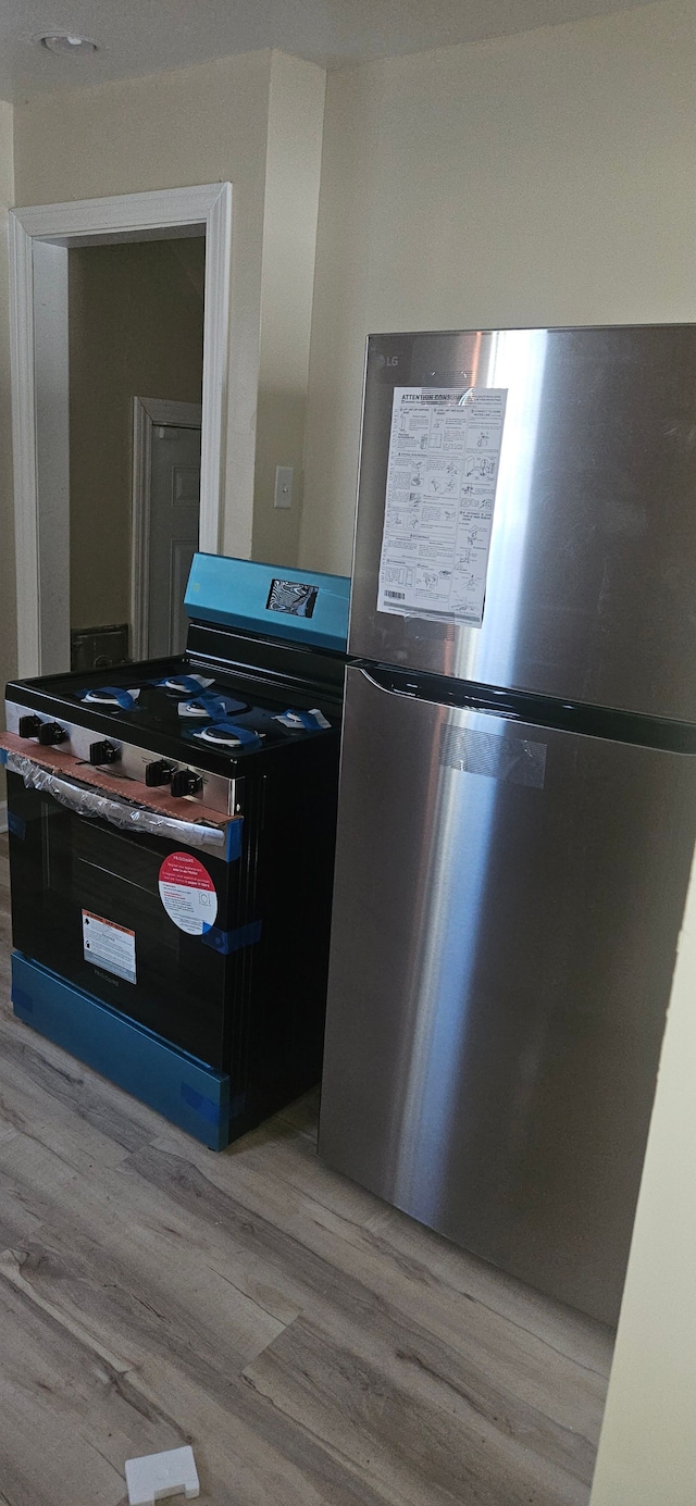 kitchen featuring light hardwood / wood-style flooring and appliances with stainless steel finishes